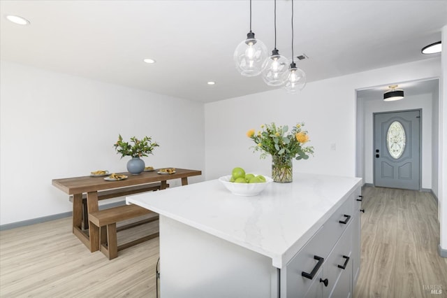 kitchen with light wood-style floors, recessed lighting, baseboards, and a kitchen island