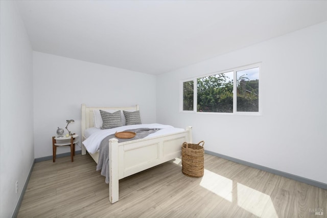 bedroom featuring baseboards and light wood finished floors