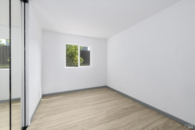 unfurnished room with light wood-style floors and baseboards