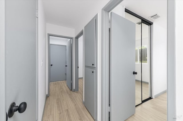 hallway with visible vents and light wood-style floors