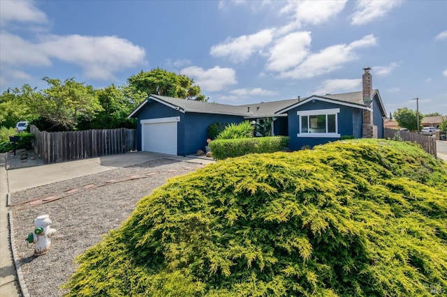 ranch-style house with a garage, fence, a chimney, and driveway