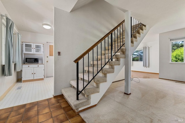 staircase with visible vents and baseboards