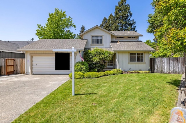 traditional home featuring fence, an attached garage, concrete driveway, and a front lawn