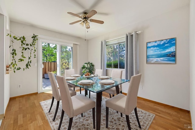 dining area with a ceiling fan, baseboards, and light wood finished floors