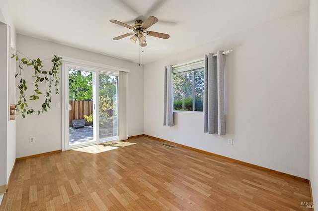 spare room with a ceiling fan, baseboards, visible vents, and light wood finished floors