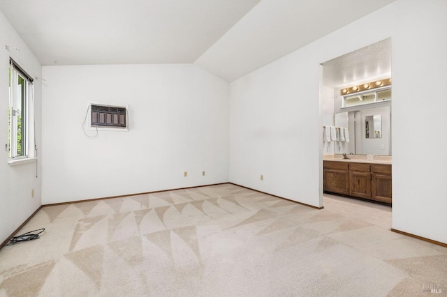 unfurnished bedroom featuring baseboards, light carpet, vaulted ceiling, and a wall mounted air conditioner