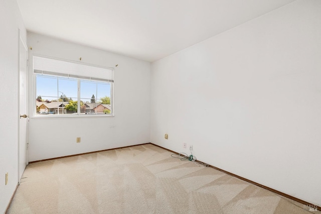 carpeted empty room featuring baseboards