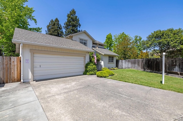 traditional home featuring driveway, a garage, fence, a front lawn, and a shingled roof