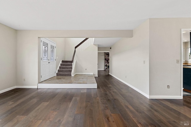 entryway featuring baseboards, stairs, and wood finished floors