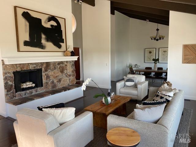 15 Main Dr, San Rafael, CA 94901 - living area featuring beam ceiling, high vaulted ceiling, a fireplace, an inviting chandelier, and baseboards