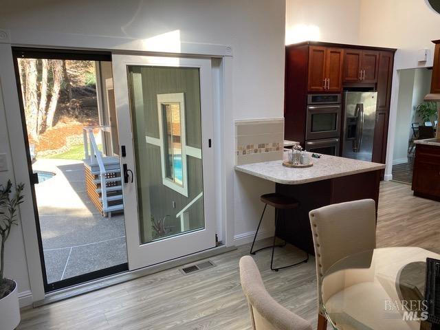 15 Main Dr, San Rafael, CA 94901 - interior space featuring light wood-type flooring, visible vents, light countertops, appliances with stainless steel finishes, and decorative backsplash