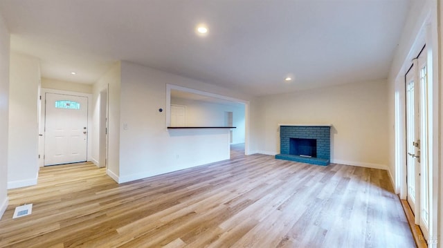 unfurnished living room with baseboards, light wood-style flooring, and visible vents