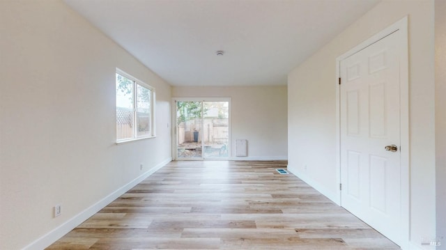 unfurnished room featuring baseboards and light wood finished floors