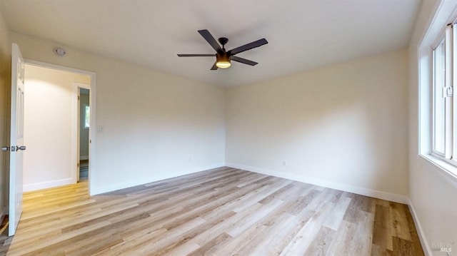 unfurnished room with baseboards, light wood-style flooring, and ceiling fan