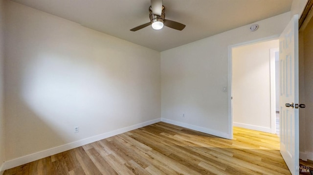unfurnished room featuring baseboards, light wood-style flooring, and ceiling fan