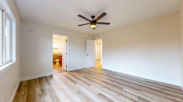 unfurnished bedroom featuring light wood-style floors, baseboards, and multiple windows