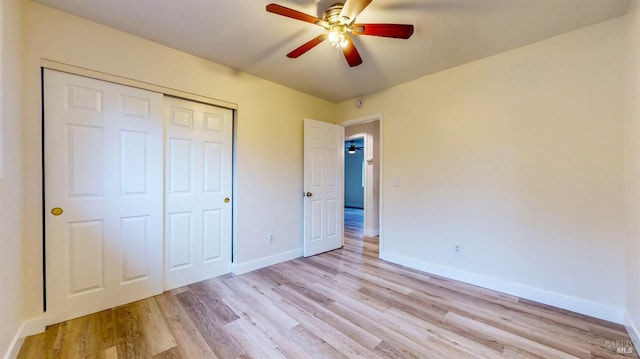 unfurnished bedroom with baseboards, ceiling fan, a closet, and light wood finished floors