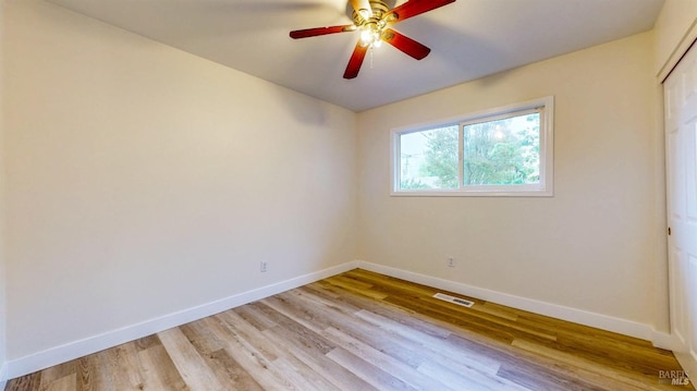spare room featuring baseboards, visible vents, ceiling fan, and light wood-type flooring