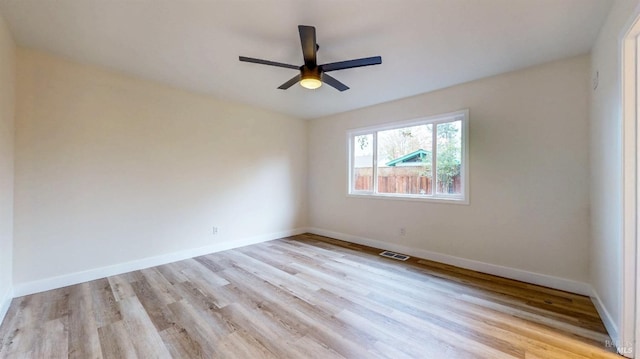 unfurnished room with visible vents, light wood finished floors, ceiling fan, and baseboards