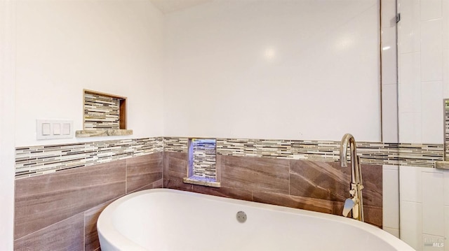 bathroom featuring a freestanding tub and tile walls