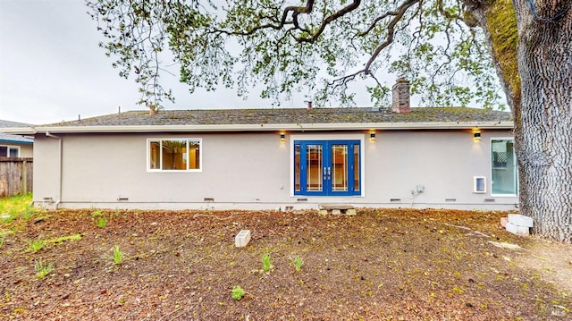 rear view of house featuring fence, stucco siding, french doors, a chimney, and crawl space