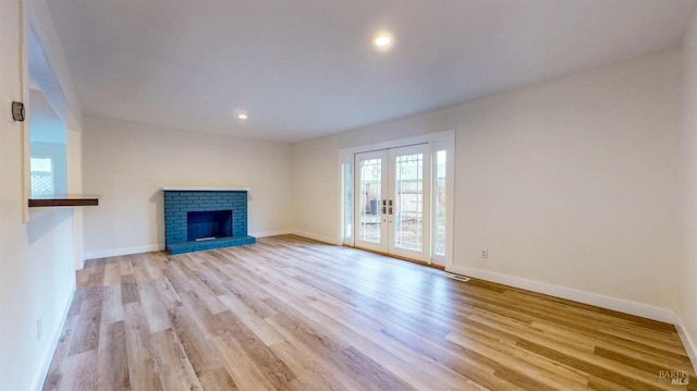 unfurnished living room with french doors, light wood-style flooring, recessed lighting, baseboards, and visible vents