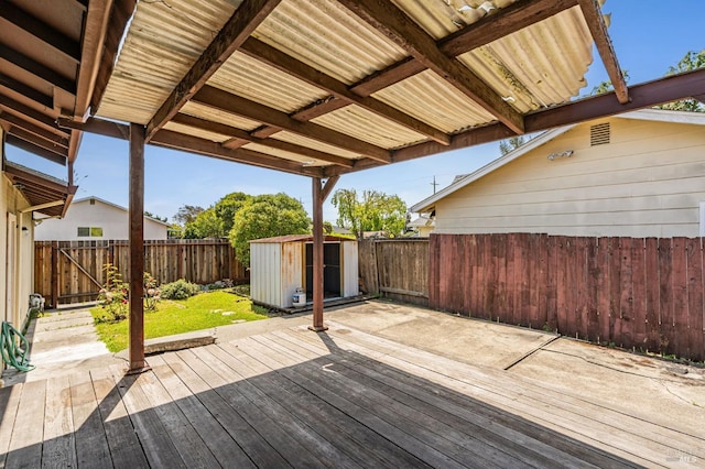 deck with an outdoor structure, a fenced backyard, and a storage shed
