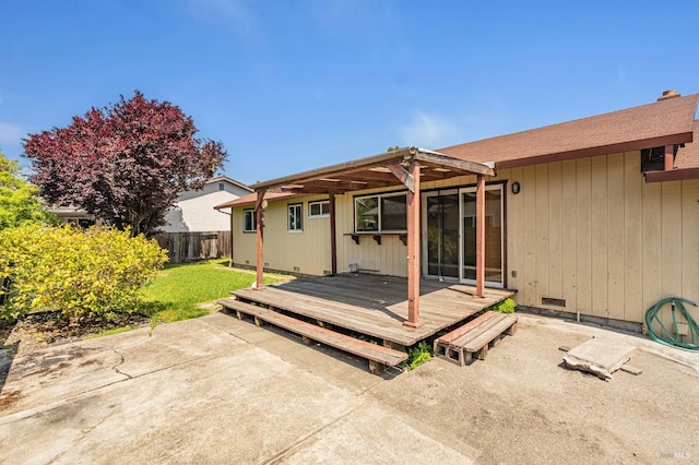 rear view of house with crawl space, a lawn, a deck, a patio area, and a fenced backyard