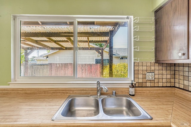 kitchen featuring backsplash, a sink, and light countertops
