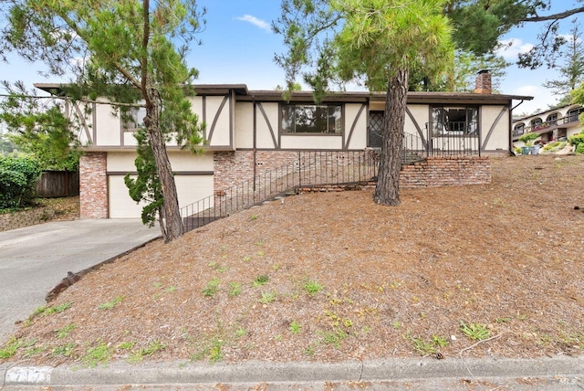 view of front of property featuring a garage, stucco siding, a chimney, and concrete driveway