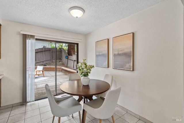 dining space with a textured ceiling and light tile patterned floors