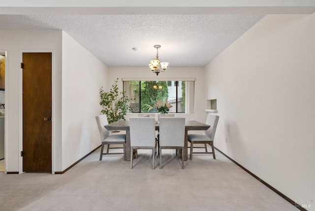 dining room with a textured ceiling, baseboards, a notable chandelier, and carpet