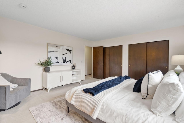 bedroom featuring two closets and light carpet