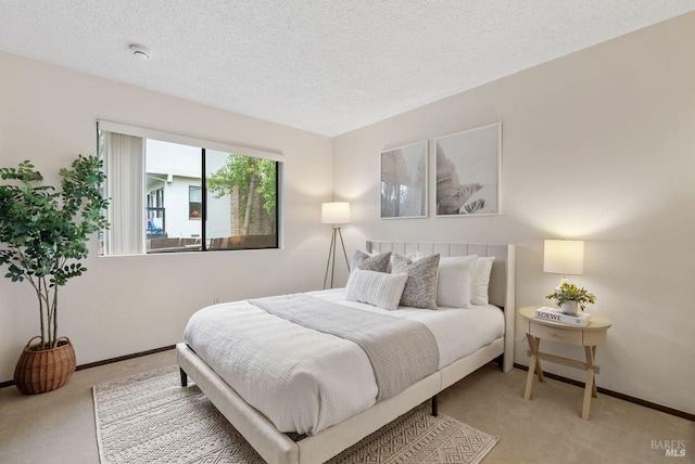 carpeted bedroom featuring baseboards and a textured ceiling