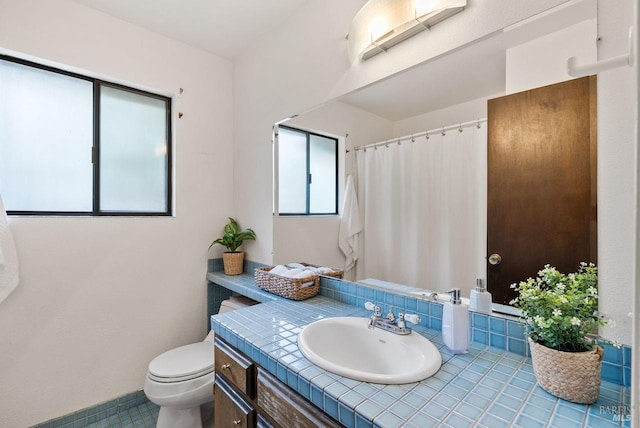 bathroom featuring toilet, tile patterned floors, plenty of natural light, and vanity