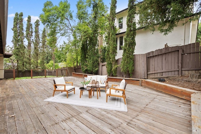 wooden deck with an outdoor living space and a fenced backyard