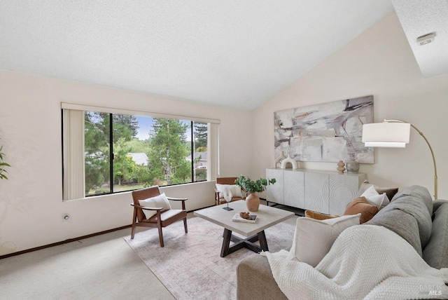 living area featuring carpet flooring, baseboards, and vaulted ceiling