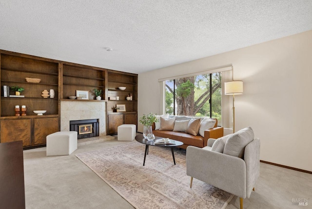 living room with a tiled fireplace, baseboards, light carpet, and a textured ceiling