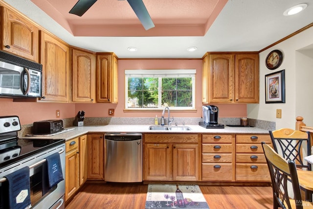 kitchen featuring light countertops, stainless steel appliances, a sink, and light wood-type flooring