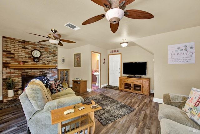 living room featuring a ceiling fan, baseboards, visible vents, and wood finished floors