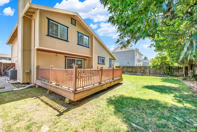 back of house with a deck, a fenced backyard, a chimney, cooling unit, and a lawn