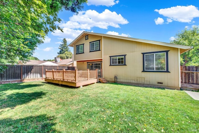 back of property with a fenced backyard, a wooden deck, and a yard