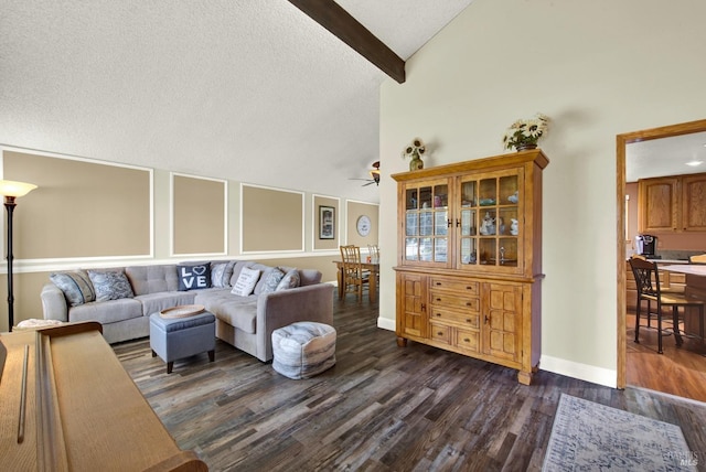 living room with ceiling fan, dark wood-style flooring, a textured ceiling, baseboards, and vaulted ceiling with beams