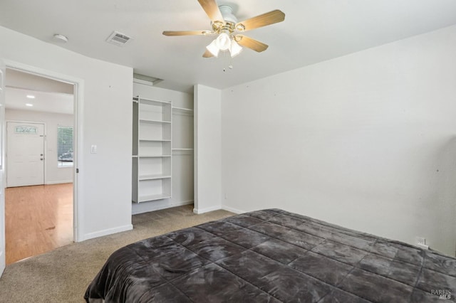 carpeted bedroom with visible vents, baseboards, ceiling fan, and a closet