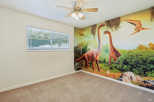spare room featuring a ceiling fan, baseboards, and carpet