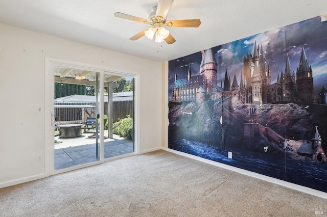 carpeted empty room with baseboards and a ceiling fan