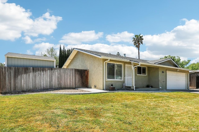 view of front of house featuring an attached garage, fence, a front yard, and stucco siding