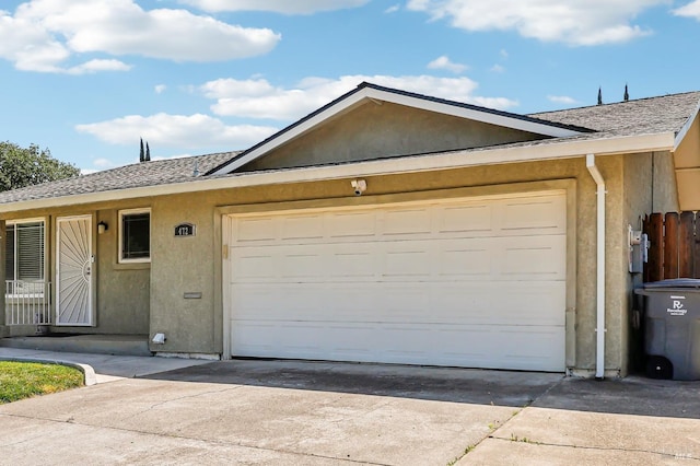 single story home with a garage, stucco siding, and concrete driveway