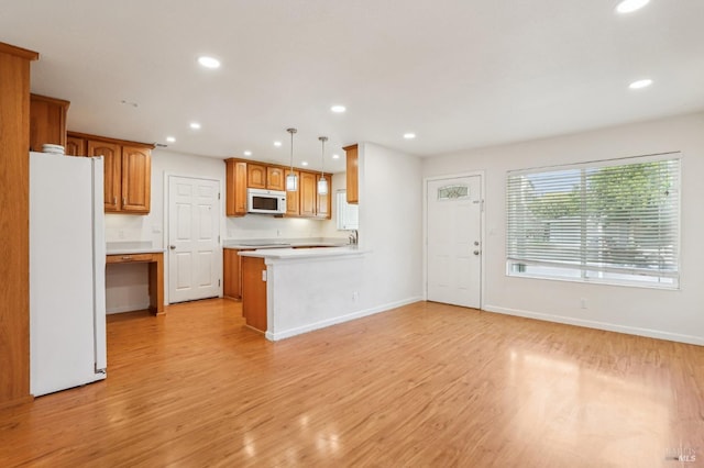 kitchen featuring recessed lighting, light wood-style flooring, and white appliances