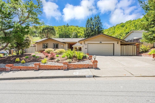 single story home featuring concrete driveway, an attached garage, and fence